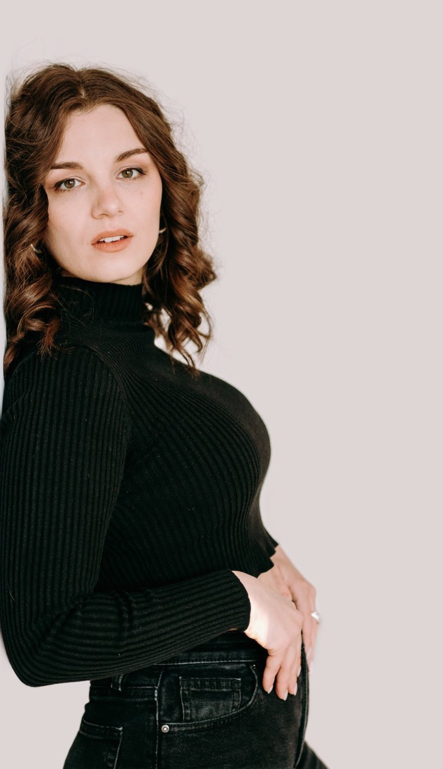Taryn in a black ribbed turtleneck, looking into the camera